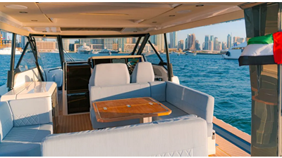 ICE 12 Saxdor 400 GTO ICE cockpit lounge with wraparound seating, wooden dining table, and panoramic Dubai Marina skyline views.