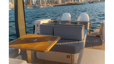 ICE 14 Saxdor 400 GTO ICE cockpit lounge with wraparound seating, wooden dining table, and panoramic Dubai Marina skyline views.