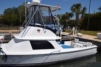 RAMPAGE 40 1976 Bertram Flybridge Cruiser docked, featuring sleek design and spacious deck under clear blue sky