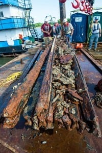Archeologists Parker Brooks, Jim Jobling and James Duff, examine a piece of casemate, made of railroad ties and timber, which served as the outer layer of armor for CSS Georgia.