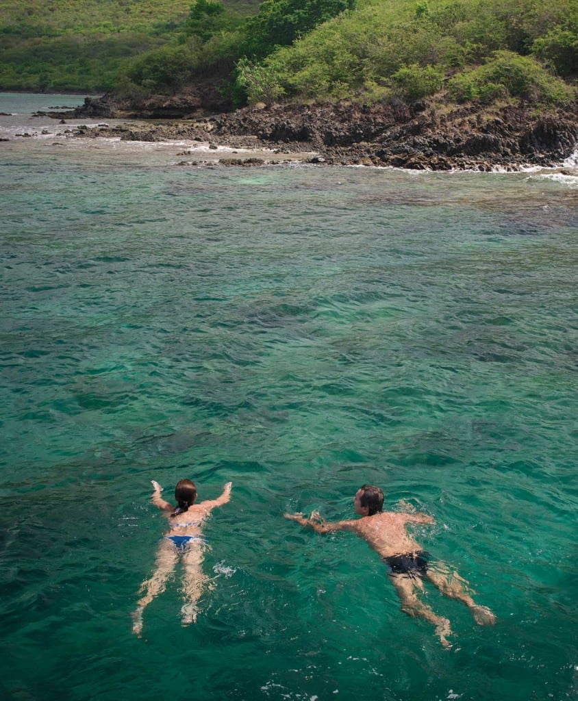 A couple swims in the clear waters of Martinique