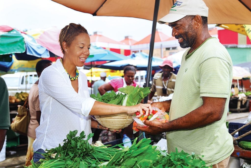 This is an image of Nina Compton buying peppers at the local market in Saint Lucia.