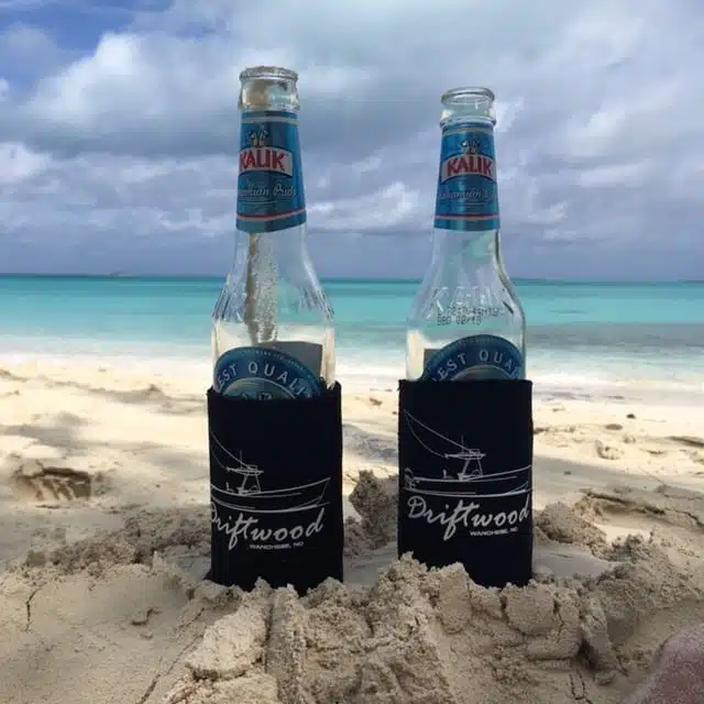 an image of Kalik beer bottles in the sand.