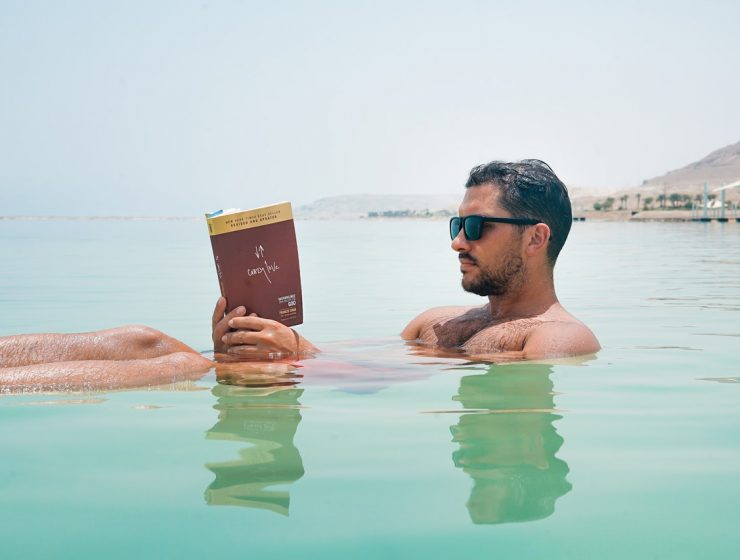 an image of a man reading in the water: what we're reading