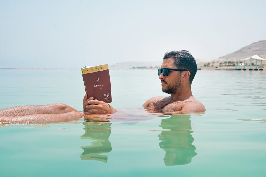 an image of a man reading in the water: what we're reading