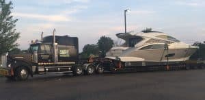 A Yacht being transported on a flat-bed semi-truck