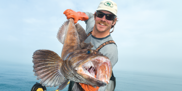 A man holds a fish showing an example of the perfect fishing photo