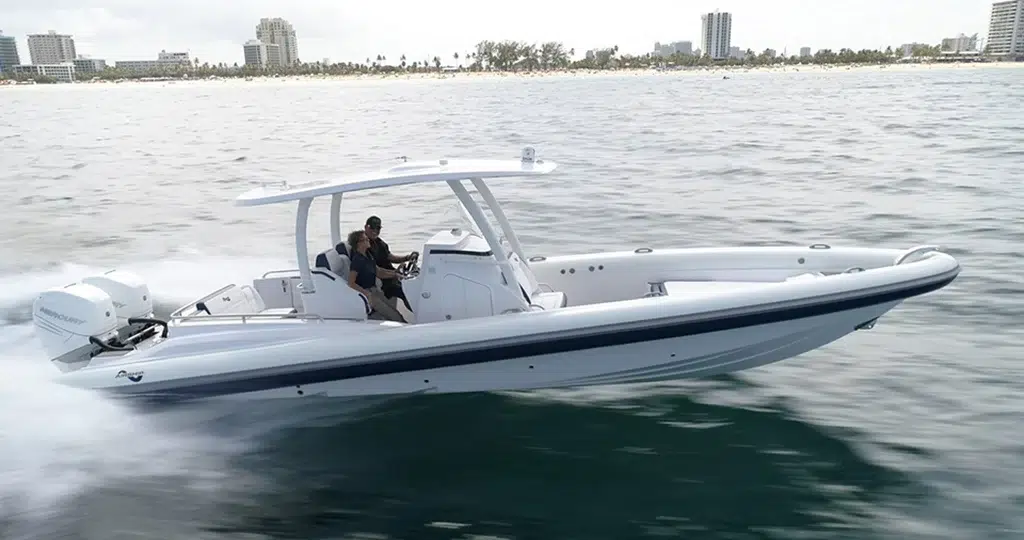 A couple in their Airship 35 RIB with a city far in the backdrop