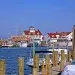 Jersey Shore Cruising example of Point Pleasant. Dock pilings cover the foreground with water and buildings in the background.