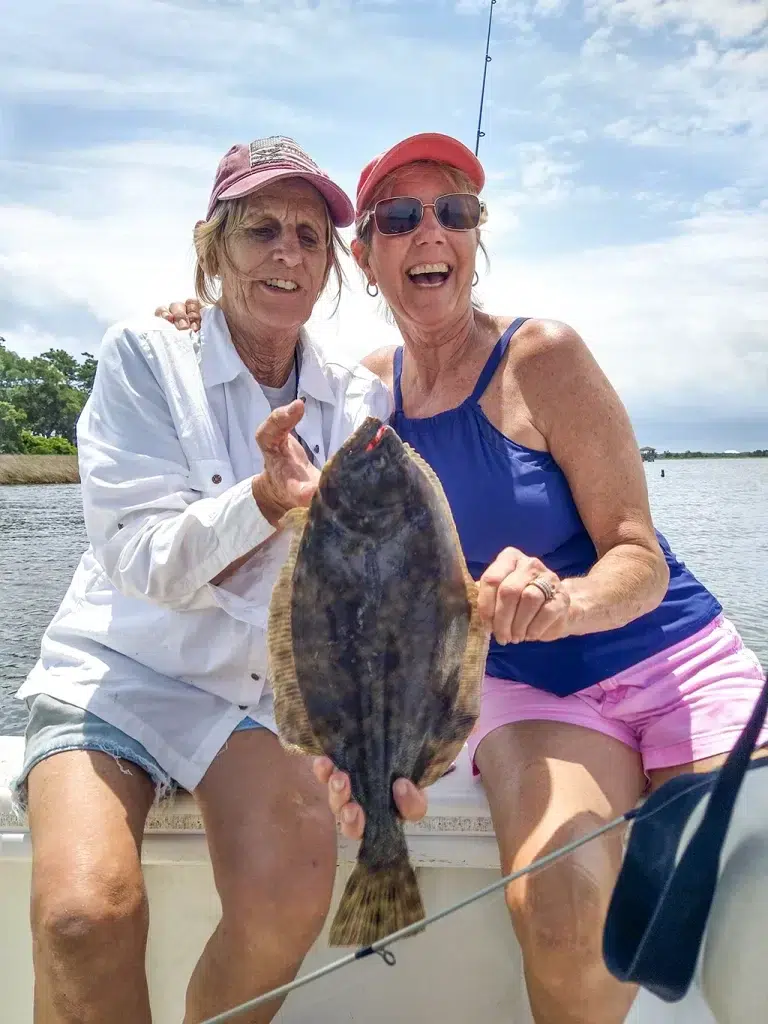 Amanda King and Female Angler hold up a catch