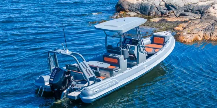 The Highfield Sport 800 sitting on water next to a rocky landing
