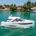 A Jeanneau boat in blue-green waters near luxury homes