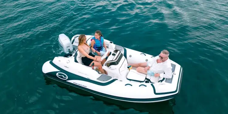 A three person family sititng on a Walker Bay Generation 12 floating on still waters
