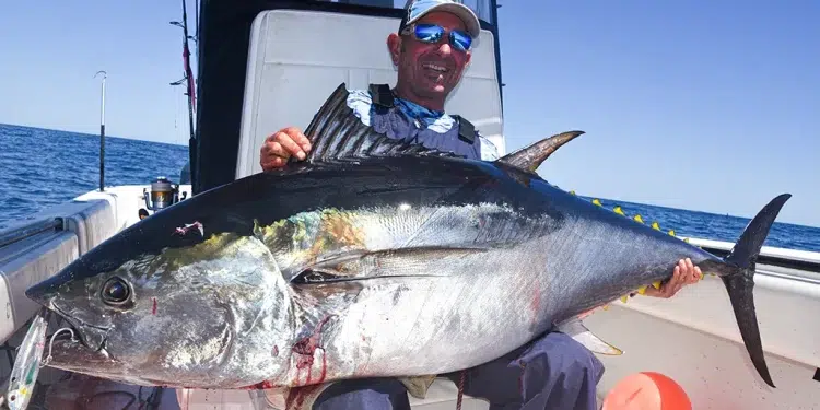 Man holds Large Tuna aboard his center console