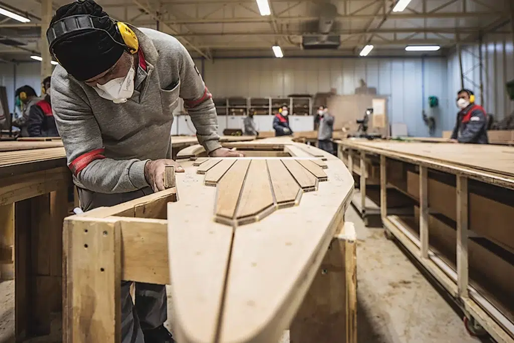 man working a wood design in the Sirena Yachts facility