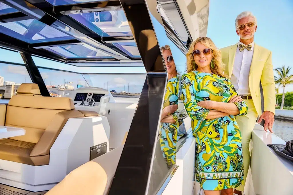 A couple poses together on their yacht while docked