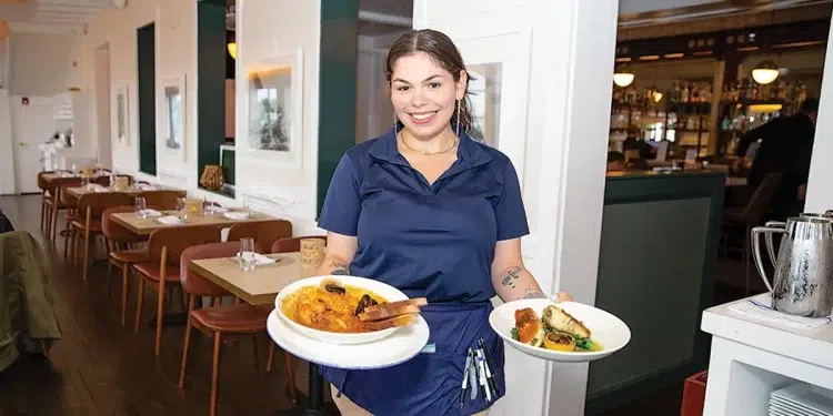 Claudios restaurant server holding two plates of food in Greenport, NY