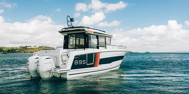 The Jeanneau NC 895 Series 2 facing the open water with hills of to its port side.