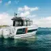 The Jeanneau NC 895 Series 2 facing the open water with hills of to its port side.