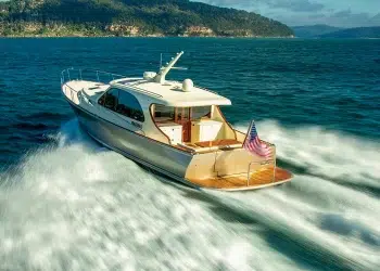 The Stylish Palm Beach PB 55 gliding across water towards an island
