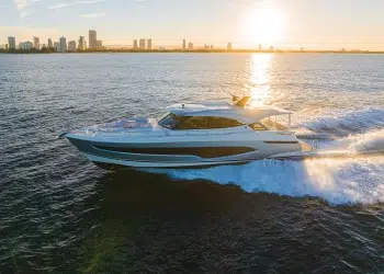 Riviera 6800 Sport Yacht Platinum Edition Running with sun setting behind a cityscape backdrop