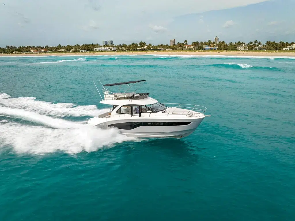 Beneteau 410 express cruiser boat running across blue waters with an island backdrop