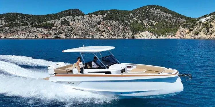 The STERK 31 cutting across blue waters with an island backdrop