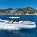 The STERK 31 cutting across blue waters with an island backdrop