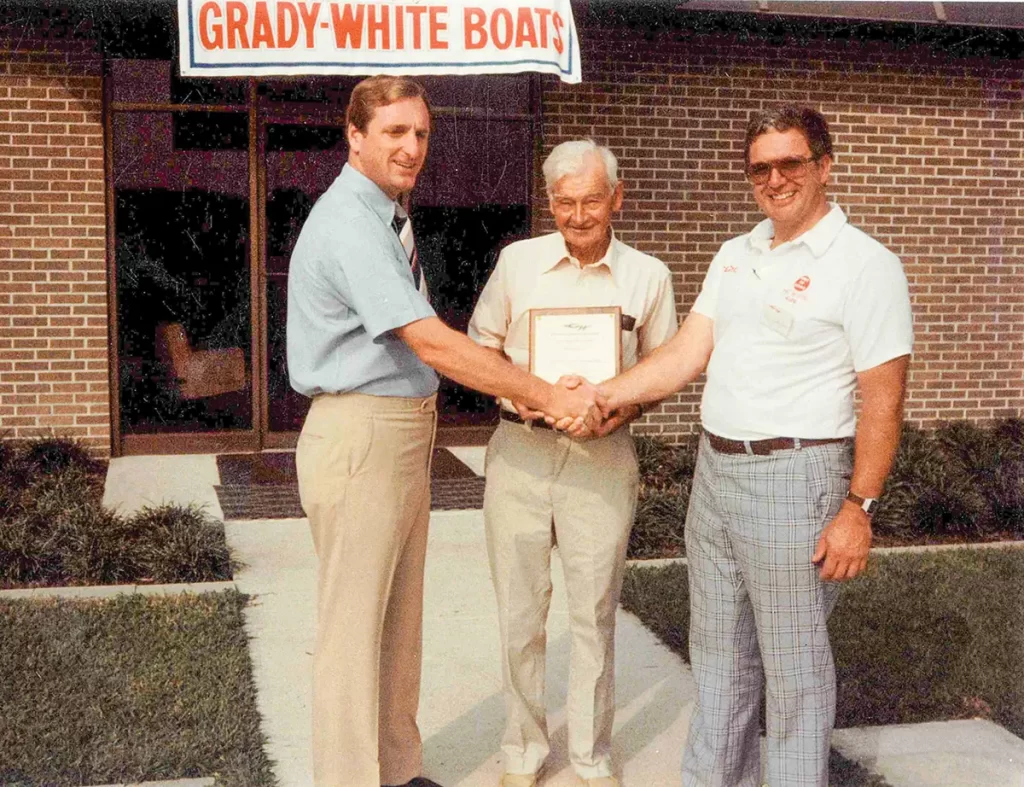 Eddie Smith, Bill Sr, and Bill Jr vintage photo in front of the Grady-White dealer entrance