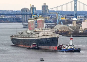 A large vessel being tugged in a port