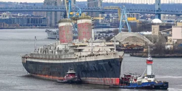 A large vessel being tugged in a port