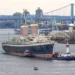 A large vessel being tugged in a port