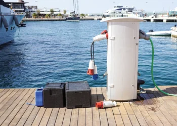 Shore power adapter on a dock with marina water as a backdrop