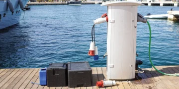 Shore power adapter on a dock with marina water as a backdrop