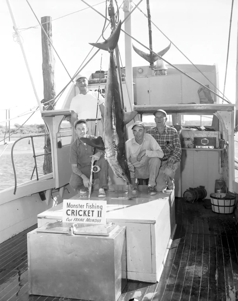 The crew of the Cricket II poses with a shark they caught.