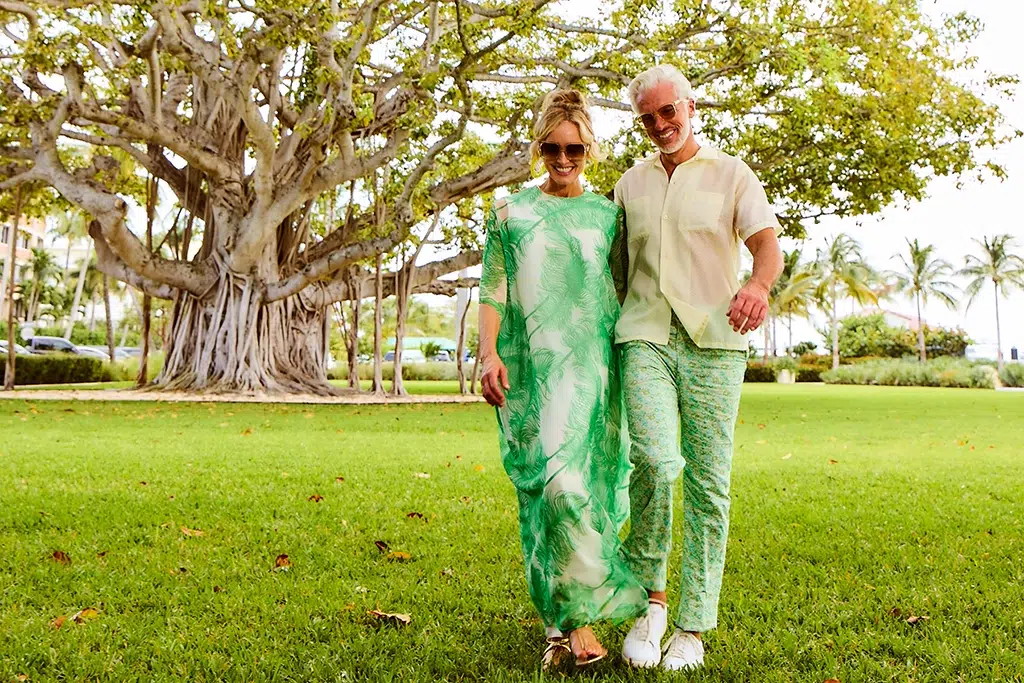 A couple casually dressed enjoy a walk in the park under a banyan tree