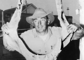 A man poses with shark jaws