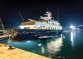 Yacht on the water lit up with boat safety lighting at night.
