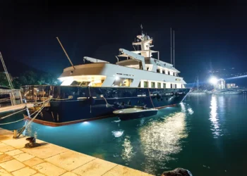 Yacht on the water lit up with boat safety lighting at night.