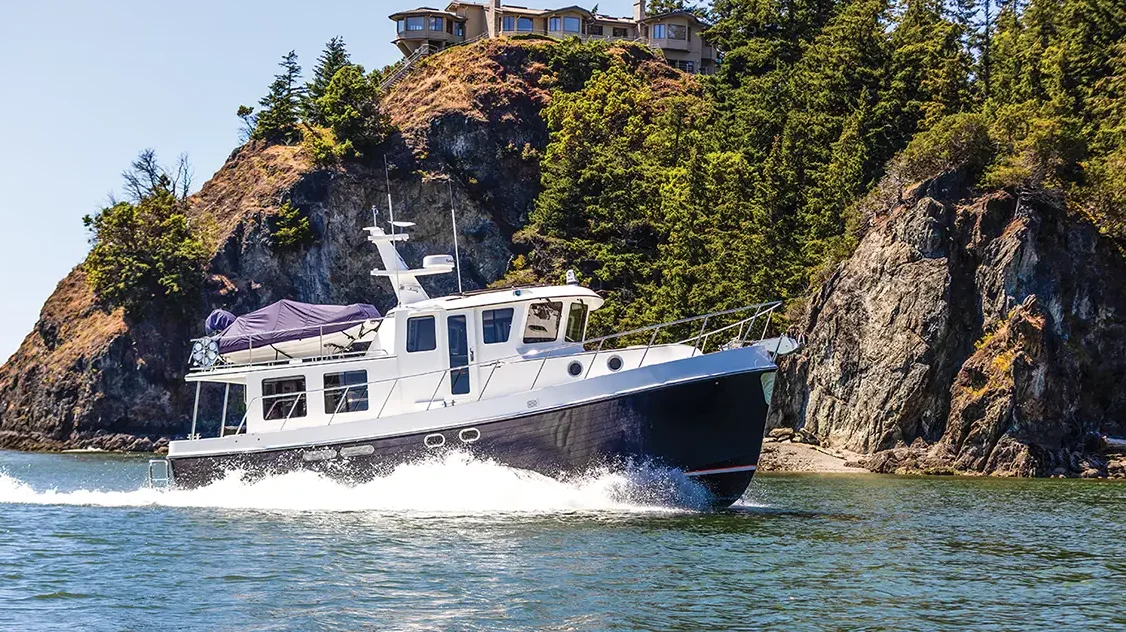 American Tug 435 white boat with dark hull tug boat running in the water