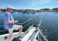 Man on the bow of his boat controlling his docking with a remote