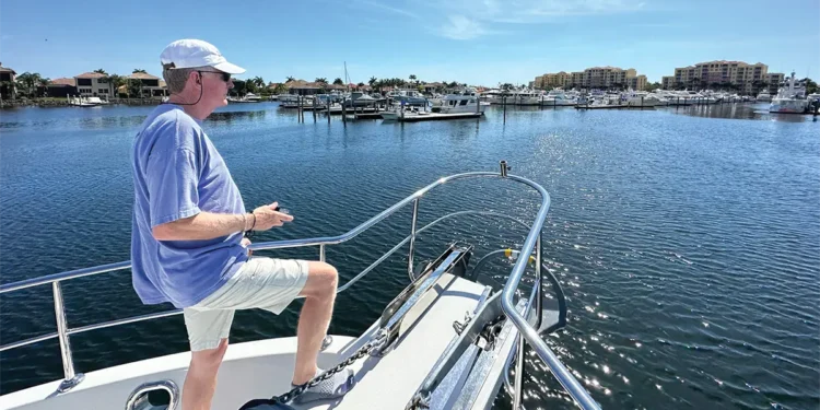 Man on the bow of his boat controlling his docking with a remote