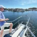 Man on the bow of his boat controlling his docking with a remote