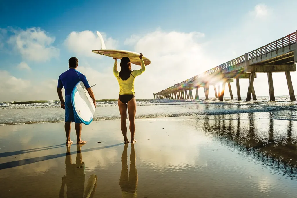 2 paddle boarders walking along Jacksonville beach