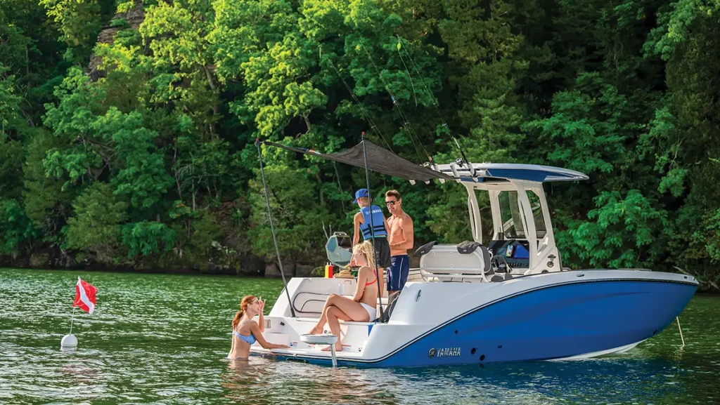 Yamaha blue hull idle in the water with 3 guests on board and one in the water