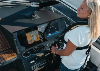 A woman at the helm using Zipwake Interceptors MFD integrations