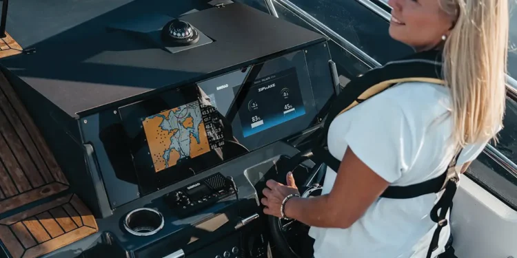 A woman at the helm using Zipwake Interceptors MFD integrations