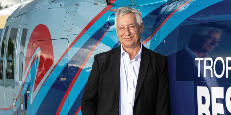 Tropic Ocean Air Founder in front of a helicopter