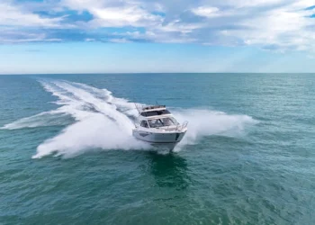 Solara S-310 SB cutting across water heading away from the horizon