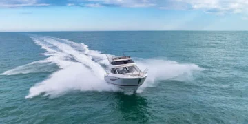 Solara S-310 SB cutting across water heading away from the horizon